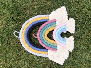 Hand-crafted rainbow tie on grass.